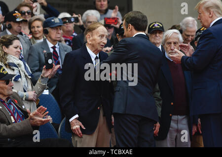 Colleville Sur Mer, France. 06th June, 2019. French President Emmanuel Macron, awardis the French National Order of Merit to a World War II veteran as U.S. President Donald Trump looks on during a commemoration ceremony marking the 75th D-Day Anniversary at the Normandy American Cemetery and Memorial June 6, 2019 in Colleville-sur-Mer, France. Thousands have converged on Normandy to commemorate the 75th anniversary of Operation Overlord, the WWII Allied invasion commonly known as D-Day. Credit: Planetpix/Alamy Live News Stock Photo