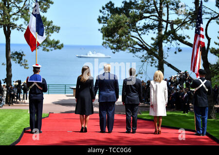 Colleville Sur Mer, France. 06th June, 2019. U.S. President Donald Trump and First Lady Melania Trump stand with French President Emmanuel Macron and his wife Brigitte Macron as they view a parade of naval ships during a commemoration ceremony marking the 75th D-Day Anniversary at the Normandy American Cemetery and Memorial June 6, 2019 in Colleville-sur-Mer, France. Thousands have converged on Normandy to commemorate the 75th anniversary of Operation Overlord, the WWII Allied invasion commonly known as D-Day. Credit: Planetpix/Alamy Live News Stock Photo