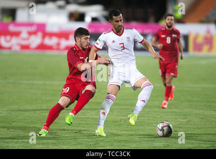 Tehran, Iran. 6th June, 2019. Ehsan Hajsafi (R) of Iran vies with Ahmad Ashkar of Syria during a friendly football match at Azadi Stadium in Tehran, Iran, June 6, 2019. Iran won 5-0. Credit: Ahmad Halabisaz/Xinhua/Alamy Live News Stock Photo