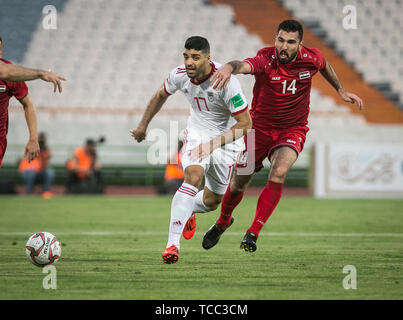 Tehran, Iran. 6th June, 2019. Mehdi Taremi (L) of Iran vies with Tamer Haj Mohamad of Syria during a friendly football match at Azadi Stadium in Tehran, Iran, June 6, 2019. Iran won 5-0. Credit: Ahmad Halabisaz/Xinhua/Alamy Live News Stock Photo