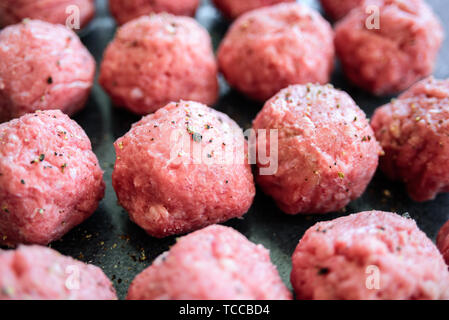 Raw uncooked turkey meatballs on tray. Fresh minced meat, pepper, salt Stock Photo