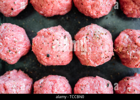 Raw uncooked turkey meatballs on tray. Fresh minced meat, pepper, salt Stock Photo