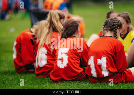 Girls in sports soccer team outdoors. Female physical education class on sports grass field. Young football players of female youth sports team Stock Photo
