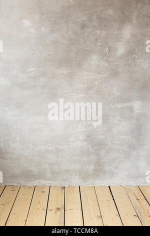 Empty gray concrete wall. Wooden floor. Free space for text. Stock Photo