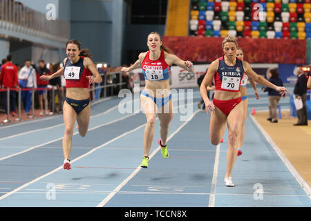 Female track and field athletes running on sunny track stock photo