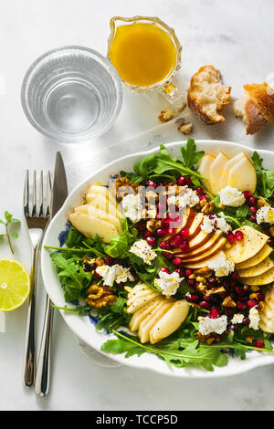 Pomegranate & Pear Green Salad with Ginger Dressing on white marble . healthy breakfast or lunch Stock Photo