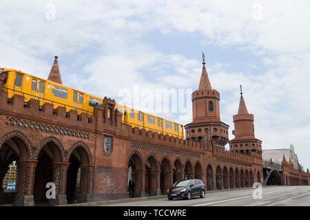 Old yellow U-Bahn subway train crossing the famous Oberbaum Bridge (Oberbaumbrucke) in Berlin, Germany, at day. Stock Photo