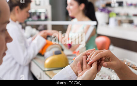 Closeup of woman hands receiving manicure and nail care procedure Stock Photo