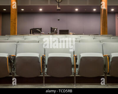 Small office auditorium with gray chairs and computer monitor set up in rear Stock Photo