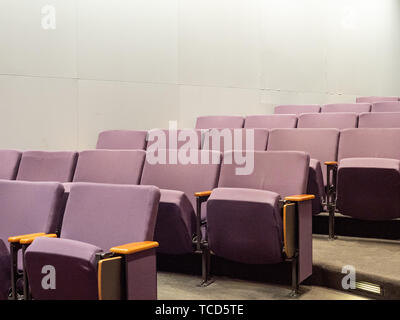 Purple theater style chairs in empty clean small auditorium Stock Photo