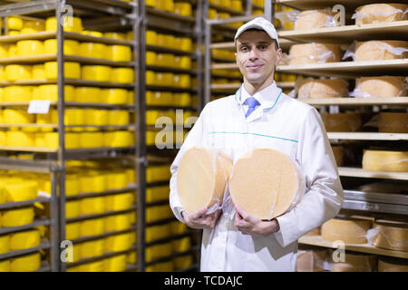 Portrait of inspector standing in production department of dairy factory and take view of redy production Stock Photo