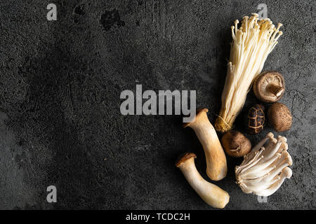 Fresh mixed forest mushrooms on the wooden black table, top view. Copy space Stock Photo