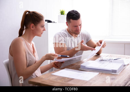 Young Couple Arguing About Expensive Invoice At Home Stock Photo