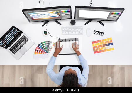 Young Female Designer Editing Photos On Computer In Office Stock Photo