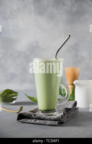 Green matcha tea and milk in latte glass on grey table. Top view. Space for text. Close up. Stock Photo