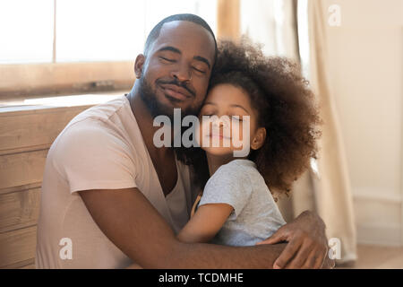 Loving african family cute funny child daughter embrace happy father Stock Photo