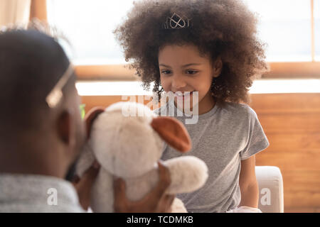Cute african kid daughter princess wearing crown playing with dad Stock Photo