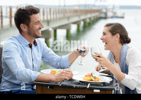 romantic couple in love having dinner at sea beach restaurant Stock Photo