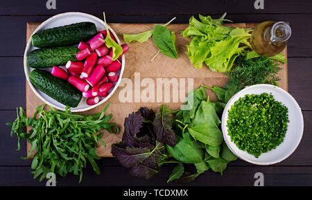 Ingredients for fresh salad of cucumbers, radishes and herbs. Flat lay. Top view Stock Photo