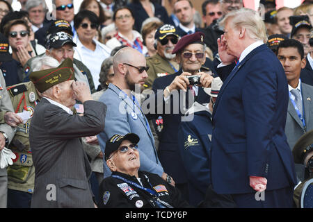A World War II veteran salutes President Donald J. Trump at the 75th D-Day Anniversary ceremony at Normandy American Cemetery and Memorial in Colleville-sur-Mer, France, June 6, 2019.     More than 1,300 U.S. Service Members, partnered with 950 troops from across Europe and Canada, have converged in northwestern France to commemorate the 75th anniversary of Operation Overlord, the WWII Allied Invasion of Normandy, commonly known as D-Day. Stock Photo