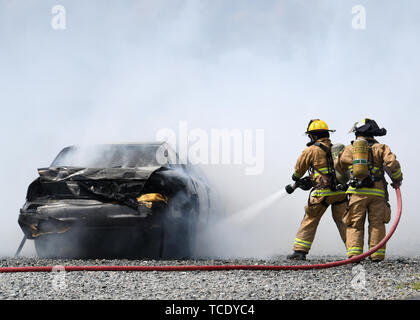 Firefighters put out a car fire during Exercise Global Dragon 2019 May 31, 2019, Perry, Ga. Live fire training during a 24 hour exercise provided the Airmen from the fire department with the opportunity to get comfortable with fire in controlled scenarios so that they know how to react in a real world situation.  (U.S. Air National Guard photo by Airman Sara Kolinski) Stock Photo