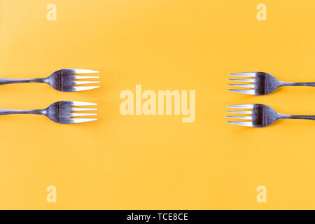 Border frame of forks, set isolated on yellow background.Frame of the Cutlery forks. Chef Recommends, kitchen utensils and tablecloth concept. Menu Stock Photo