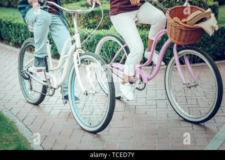 Bicycle riding. Close up of beautiful new bicycles being in use by a nice pleasant couple Stock Photo