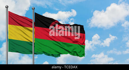 Bolivia and Malawi flag waving in the wind against white cloudy blue sky together. Diplomacy concept, international relations. Stock Photo