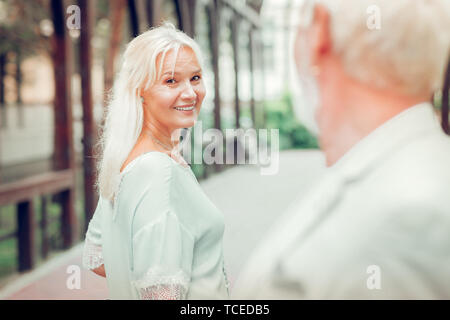 Being in love. Happy nice woman smiling while looking at her beloved man Stock Photo