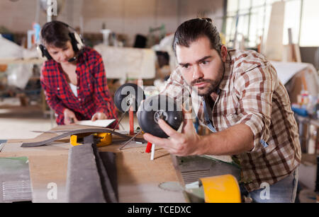 Male aircraft enthusiast working in workshop on creating of airplane models Stock Photo