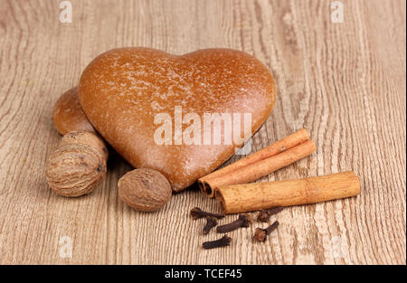 Heart-shaped cookies with cinnamon, nutmegs and carnation on wooden background Stock Photo