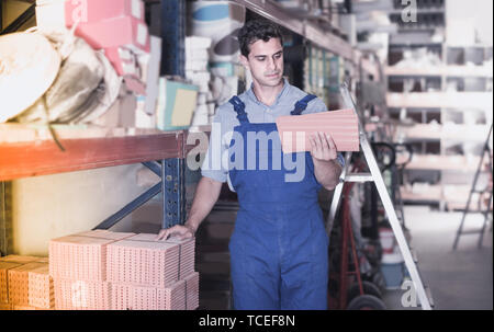 Builder is choosing tiles in the building store. Stock Photo