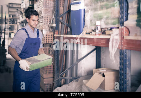 male in uniform is choosing cement in the building store room Stock Photo
