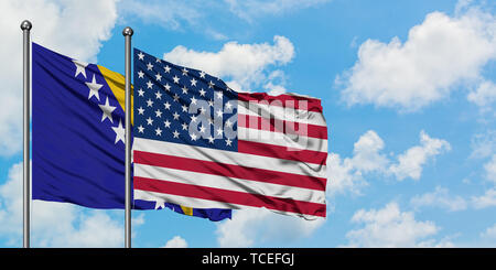 Bosnia Herzegovina and United States flag waving in the wind against white cloudy blue sky together. Diplomacy concept, international relations. Stock Photo