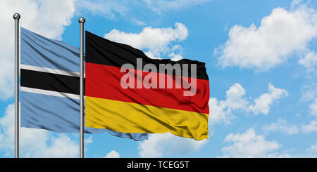 Germany and Botswana flag waving in the wind against white cloudy blue ...
