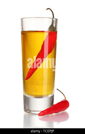 glass of pepper vodka and red chili peppers isolated on white Stock Photo