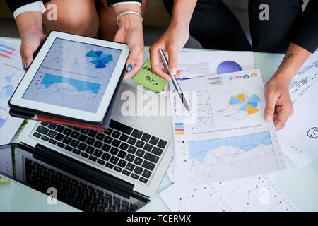 Hands of female entrepreneurs discussing financial documents and reports at meeting Stock Photo
