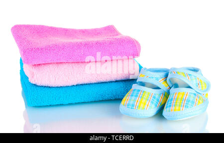 Blue baby booties and three colorful towels isolated on white Stock Photo