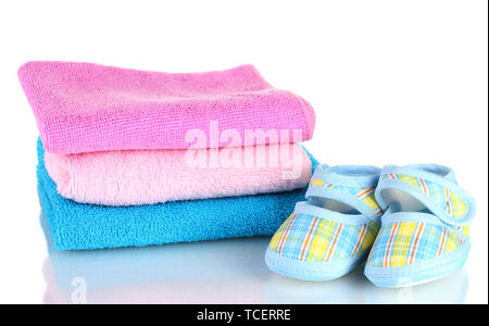 Blue baby booties and three colorful towels isolated on white Stock Photo