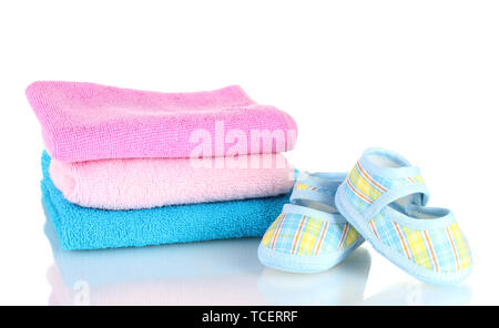 Blue baby booties and three colorful towels isolated on white Stock Photo