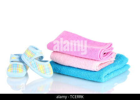 Blue baby booties and three colorful towels isolated on white Stock Photo