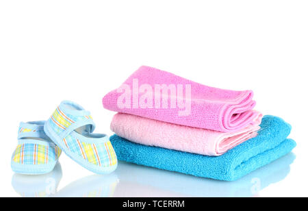 Blue baby booties and three colorful towels isolated on white Stock Photo