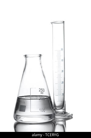 Flask with water and empty measuring beaker with reflection isolated on white Stock Photo