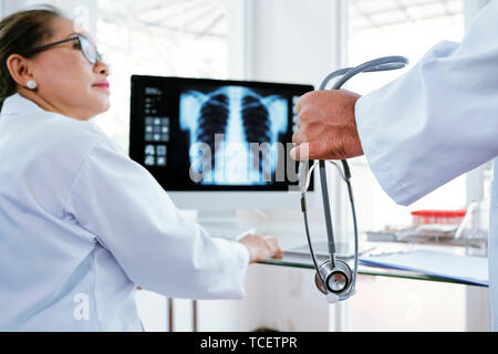 Female doctor looking at her coworker taking off stethoscope in the end of shift Stock Photo