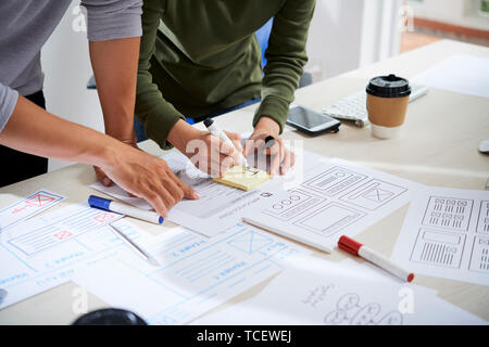 Hands of UX designers discussing documents and working on website wireframe design Stock Photo