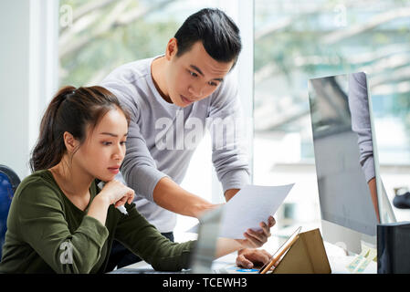 UX designer showing project sketch he made young pensive project manager Stock Photo