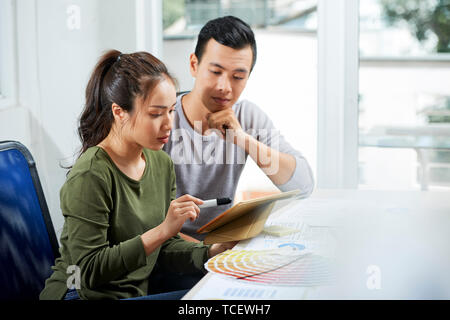 Team of UI designers discussing color scheme for new application for tablet computers Stock Photo