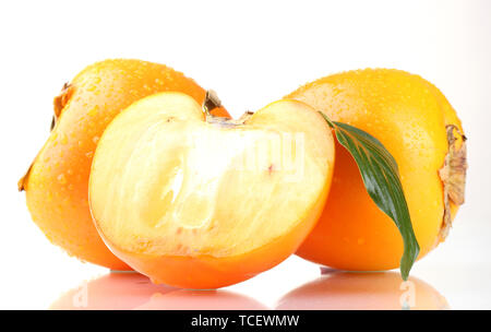 Appetizing persimmons with droplets and leaves isolated on white Stock Photo