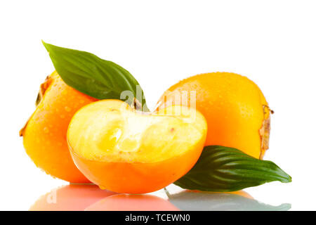 Appetizing persimmons with droplets and leaves isolated on white Stock Photo