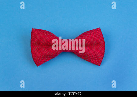 Red bow-tie on blue background. Happy fathers day concept. Minimalistic design Stock Photo
